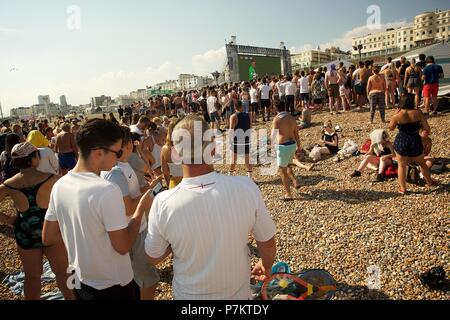 Brighton, UK. 7 juillet 2018. Les fans de football sur la plage de Brighton à regarder le grand écran sur la plage à travers les obstacles Crédit : Rupert Rivett/Alamy Live News Banque D'Images