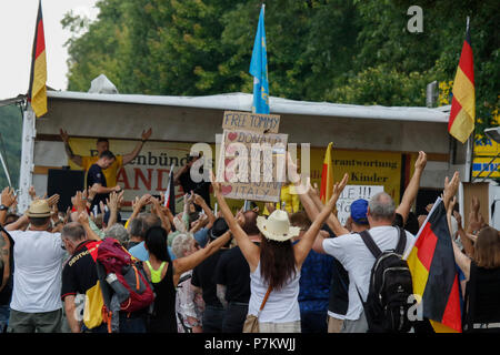 Kandel, Allemagne. 7 juillet 2018. Les manifestants de droite écouter un discours au rassemblement, holding drapeaux allemands et un signe qui appelle à une libération de la militante d'extrême droite, Tommy Robinson et montre leur soutien à Donald Trump, Vladimir Poutine, Viktor Orban, Sebastian Kurz (Chancelier autrichien) et l'Italie. Autour de 200 personnes d'organisations d'extrême droite ont protesté pour la 10. heure de la ville de Kandel en Palatinat, contre les réfugiés, les étrangers et le gouvernement allemand. Crédit : Michael Debets/Alamy Live News Banque D'Images