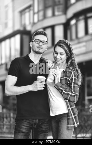 Portrait of happy couple marche dans la rue avec du café. Banque D'Images