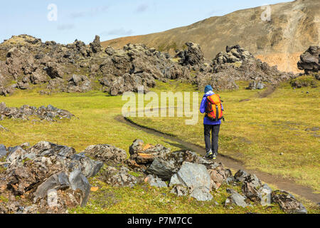 Sentier : un Graenagil trekker est marche à travers le champ de lave Laugahraun à Landmannalaugar, la Réserve Naturelle de Fjallabak, Highlands, Région du Sud, Islande, Europe, Banque D'Images