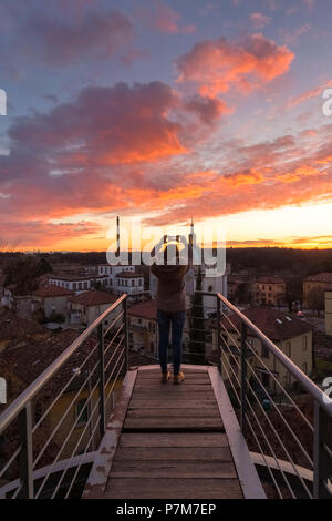 Turist une prise d'une photo lors d'un coucher de soleil sur le balcon sur le modèle Village Ouvrier de Crespi d'Adda, UNESCO World Heritage Site. Capriate San Gervasio, province de Bergame, Lombardie, Italie. Banque D'Images