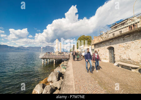 Les touristes à marcher le long du lac de Torri del Benaco sur la rive orientale du lac de Garde, Vérone, Vénétie, Italie province. Banque D'Images