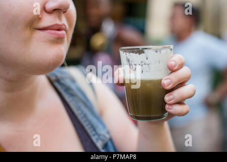 Un touriste tente guarapo-a appuyé sur la canne à sucre verre-pour la première fois lors de la marche autour de La Havane. Banque D'Images