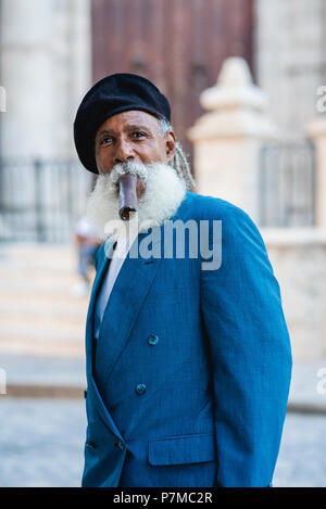 Impeccablement vêtu d'un homme qui fume un cigare géant dans les rues de La Havane, Cuba. Il a été présenté dans le National Geographic Traveler il y a quelques années. Banque D'Images