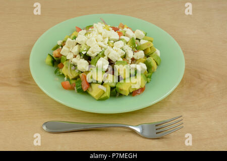 Salade de poulet à l'avocat, le concombre, la tomate et le fromage feta sur plaque verte avec la fourchette Banque D'Images