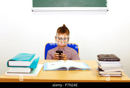 Écolier intelligent à faire leurs devoirs à l'école avec tablet pc. Banque D'Images