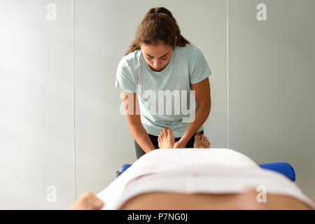 Le massage médical au pied d'un centre de physiothérapie. Physiothérapeute femelle son patient l'inspection. Banque D'Images