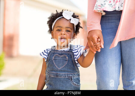 Petite fille tenant la main de sa mère. Banque D'Images