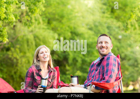 Couple parler et rire sur un voyage de camping. Banque D'Images