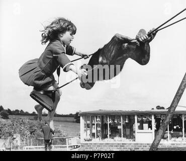 Le chimpanzé et fille sur la balançoire, Angleterre, Grande-Bretagne Banque D'Images