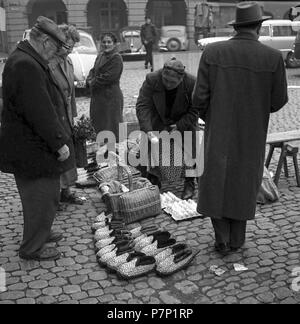 Femme vend des choses différentes (chaussures, œufs) sur une rue, Freiburger Münstermarkt, environ 1945 à 1955, Freiburg, Allemagne Banque D'Images