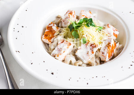 Spaghetti Pâtes au saumon, fromage et d'herbes en plaque blanche Banque D'Images