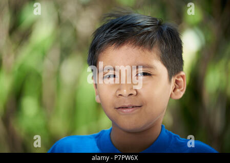 Portrait of Hispanic boy on été soleil lumière arrière-plan flou Banque D'Images