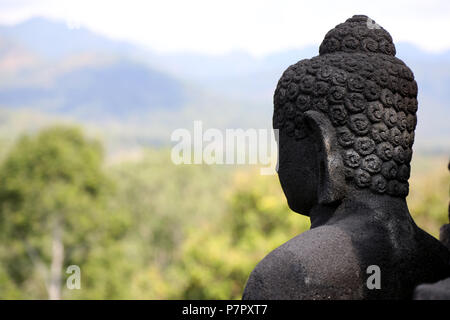 Borobudur, Indonésie - Juin 23, 2018 : une statue de Bouddha s'ouvre sur la campagne entourant le temple bouddhiste de Borobudur, près de l'Jogjaka Banque D'Images