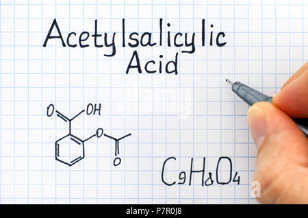 Personne part avec stylo écrit la formule chimique de l'acide acétylsalicylique. Close-up. Banque D'Images