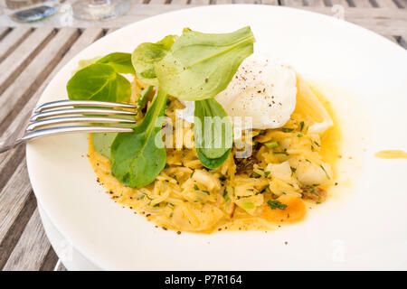 Petit-déjeuner un Kedgeree plat qui provient de l'Inde riz au curry oeuf raisins haddock fumé avec un oeuf poché sur le dessus Banque D'Images