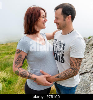 Jeune couple expecting a baby, à l'extérieur sur la montagne Banque D'Images