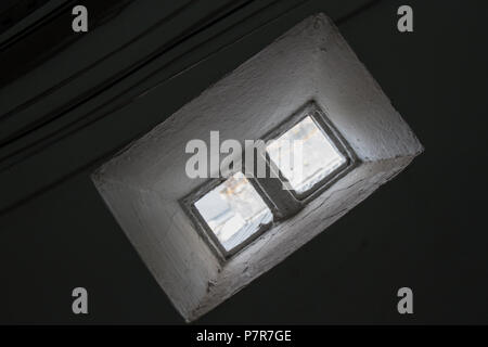 Une minuscule fenêtre faite de 2 briques de verre illumine l'air ambiant et des fils électriques qui passent. Pas de personnes. Le Brésil. L'Amérique du Sud. Banque D'Images