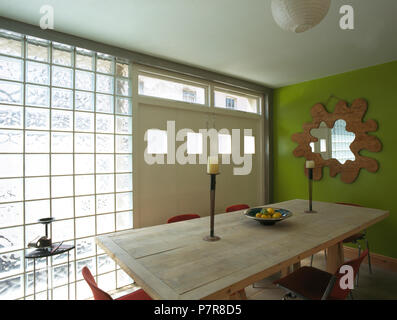 Table en bois en vert 90 salle à manger avec mur de brique de verre Banque D'Images