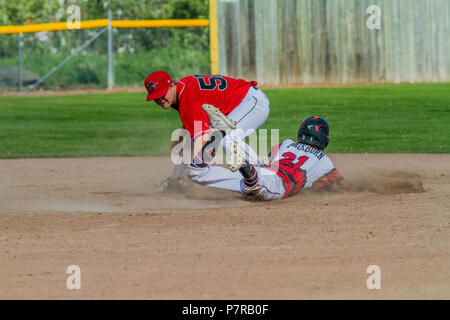 Jouer à la deuxième base en tant que runner coulisse à l'après-midi, les garçons junior de baseball jeu. Cranbrook, BC. Banque D'Images