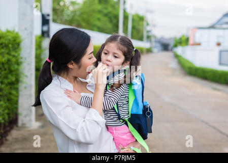 Maman nourrir sa fille avec collation avant d'aller à l'école. Retour à l'école et l'éducation concept. Home sweet home et heureuse famille thème. Banque D'Images