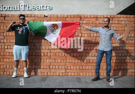 Les visiteurs titulaires d'un drapeau mexicain aide pour démonter et prendre une brique de l'artiste mexicain Bosco les œuvres de Sodi Muro, un mur construit sur la rive sud de Londres pour protester contre le président américain, Donald Trump. Le mur, qui est de deux mètres de haut et de huit mètres de long, est construit à partir de 1 600 briques fabriquées au Mexique, chacun signé par l'artiste. Les passants ont été invités à démanteler le mur brique par brique et prendre une partie de l'installation maison. Banque D'Images