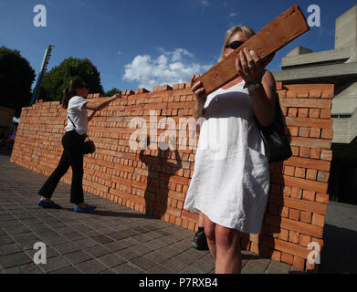 Aider les visiteurs à démanteler et à prendre une brique de l'artiste mexicain Bosco les œuvres de Sodi Muro, un mur construit sur la rive sud de Londres pour protester contre le président américain, Donald Trump. Le mur, qui est de deux mètres de haut et de huit mètres de long, est construit à partir de 1 600 briques fabriquées au Mexique, chacun signé par l'artiste. Les passants ont été invités à démanteler le mur brique par brique et prendre une partie de l'installation maison. Banque D'Images