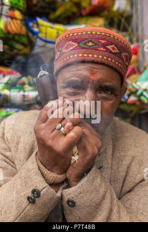 Vashisht, Inde - le 26 mai 2017 : Portrait d'un homme non identifié dans un chapeau himachali fumeurs chillum en village Vashisht, Himachal Pradesh, dans Banque D'Images