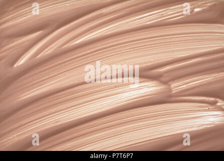 Maquillage beige crémeux de frottis foundation isolé sur fond blanc. Fondation crémeuse beige texture background Banque D'Images