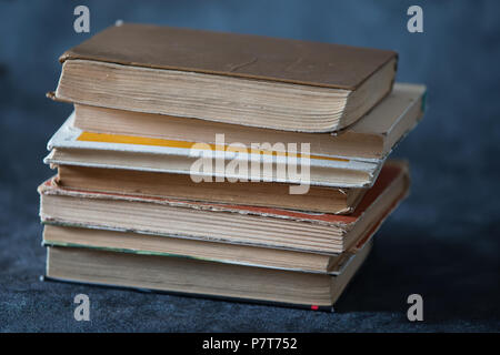 Une pile de vieux livres sur un fond gris. Books Banque D'Images