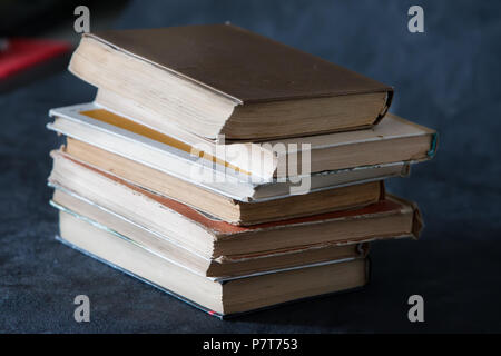 Une pile de vieux livres sur un fond gris. Books Banque D'Images