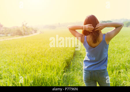 Asian girl vous détendre dans l'arrière-plan de campagne sur le terrain d'herbe Banque D'Images