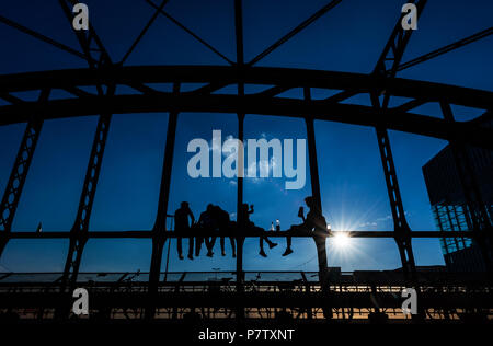 Munich, Allemagne. 07Th Juillet, 2018. Cinq jeunes gens assis sur les poutres en acier de l'Hacker-Bridge au coucher du soleil. Crédit : Peter Kneffel/dpa/Alamy Live News Banque D'Images