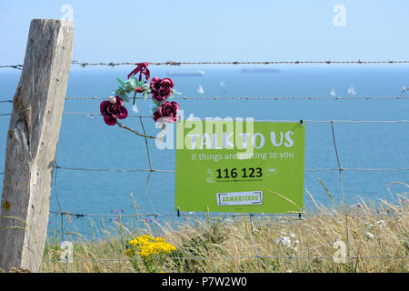 Culver, UK. 07Th Juillet, 2018. Samaritains un signe sur le bord de Culver Cliff sur l'île de Wight, dit : 'Parlez-nous si les choses deviennent pour vous' - publiée après une vague de suicides du même endroit. Yachts peuvent être vus en train de passer dans l'arrière-plan au cours de la 'Round The Island Yacht Race" sur le jour de l'année enregistrée jusqu'à présent à 33 degrés Celcius. Crédit : Matthieu Blythe/Alamy Live News Banque D'Images