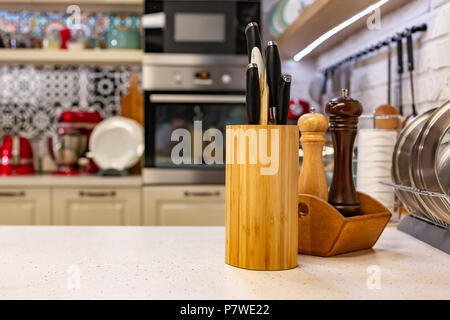 Des couteaux de cuisine dans un support en bois avec des pots d'épices. Close-up. Concept de cuisine Banque D'Images