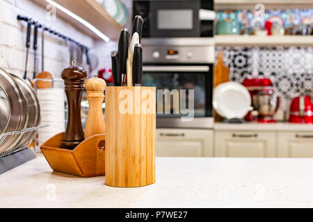 Des couteaux de cuisine dans un support en bois avec des pots d'épices. Close-up. Concept de cuisine Banque D'Images