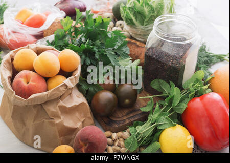 Ensemble d'alimentation saine. Les graines de quinoa noir, l'écrou, divers légumes et fruits sur une table en bois blanc Banque D'Images