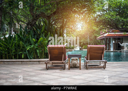 Belle chaise chaise longue près de la piscine. Vacances et détente concept. Les modes de vie et de l'intérieur du thème. Été et printemps thème. Sunligh Orange Banque D'Images