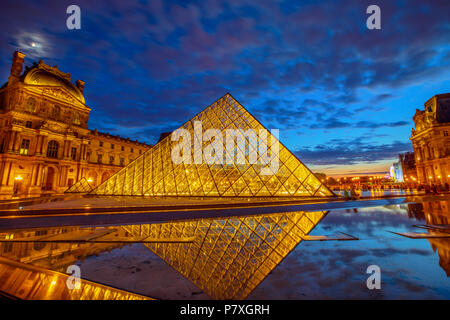 Paris, France - 1 juillet 2017 : Cour Napoléon du Musée du Louvre à l'heure bleue. Pyramide de verre et Pavillon Rishelieu reflétant dans l'eau au crépuscule. Palais du Louvre est un célèbre monument de Paris Capitale Banque D'Images