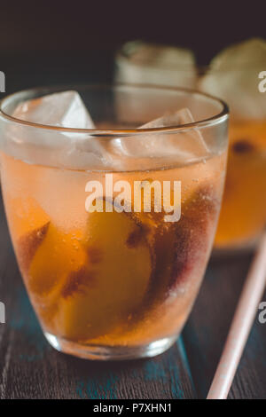 Peach aperol spritz avec tranches de pêches sur le bureau en bois. Cocktails d'été. Peach froid limonade. Banque D'Images