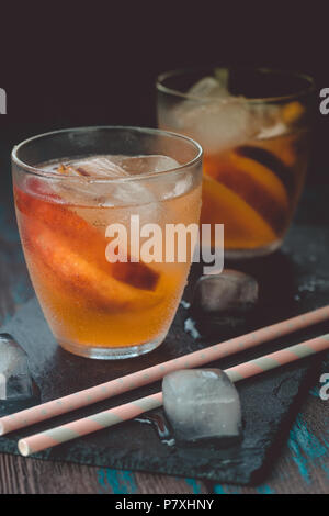 Peach aperol spritz avec tranches de pêches sur le bureau en bois. Cocktails d'été. Peach froid limonade. Banque D'Images