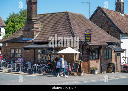 Les gens de détente à l'extérieur des tables de la chaussée de Rumsey, un artisan chocolatier Chocolaterie, de cadeaux et d'un café, High Street, Wendover, dans le Buckinghamshire. Banque D'Images