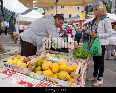 Femme achète des légumes du vendeur sur le marché en plein air dans la ville française de briancon Banque D'Images