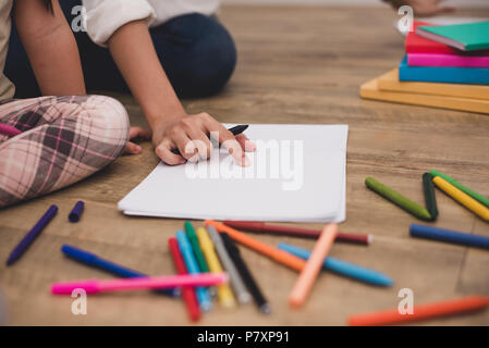 Fermé mains de maman petits enfants de l'enseignement en classe d'art dessin caricature avec tête d'impression couleur. Retour à l'école et l'éducation concept. Famille et maison Banque D'Images