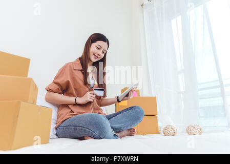 Beauty Asian woman using tablet et carte de crédit. Lancer une petite entreprise et PME LISTE D'ordre de contrôle dans la chambre, les jeunes professionnels offres wo Banque D'Images