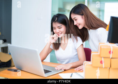 Deux jeunes fille asiatique privé d'affaires indépendant qui travaille à domicile avec ordinateur portable ou ordinateur de bureau avec un ordinateur portable sur un bureau en ligne de livraison de l'emballage. Banque D'Images