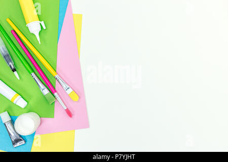 Brosses, bâton de colle, peintures, marqueurs, feuilles de papier de couleur sur fond blanc bureau école Banque D'Images