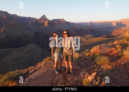 Deux jeunes femmes les randonneurs pour le coucher du soleil sur l'extrémité nord-ouest de Horseshoe Mesa dans le Parc National du Grand Canyon, Arizona, United States. Banque D'Images