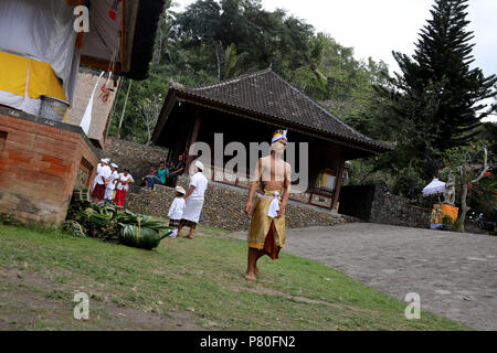 Tenganan, Indonésie - 30 juin 2018 : un homme marche à travers le village de Tenganan balinais avant le début de l'assemblée annuelle du festival de Pandan Perang Banque D'Images