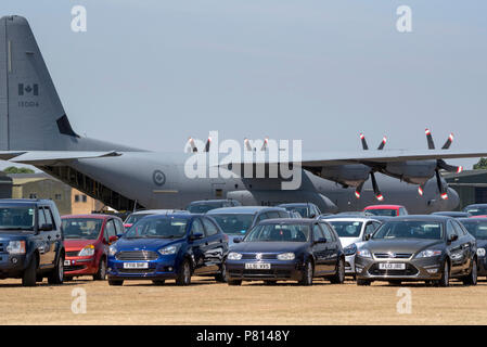 Yeovilton Royal Naval Air Station, Somerset, Royaume-Uni. A Canadian air force Lockheed C 130 Hercules et des voitures en stationnement. Banque D'Images